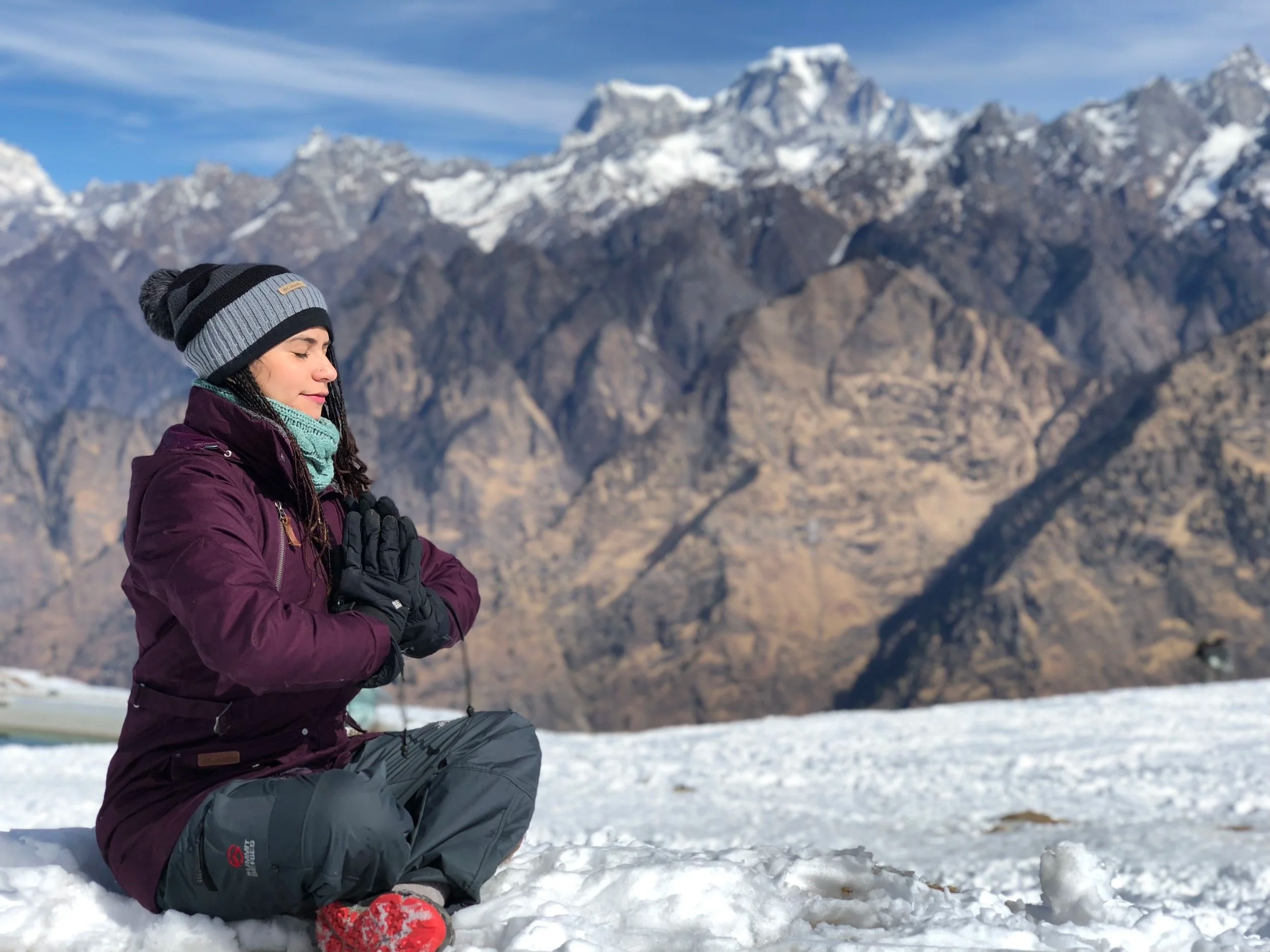 Mujer en meditación frente a la montaña